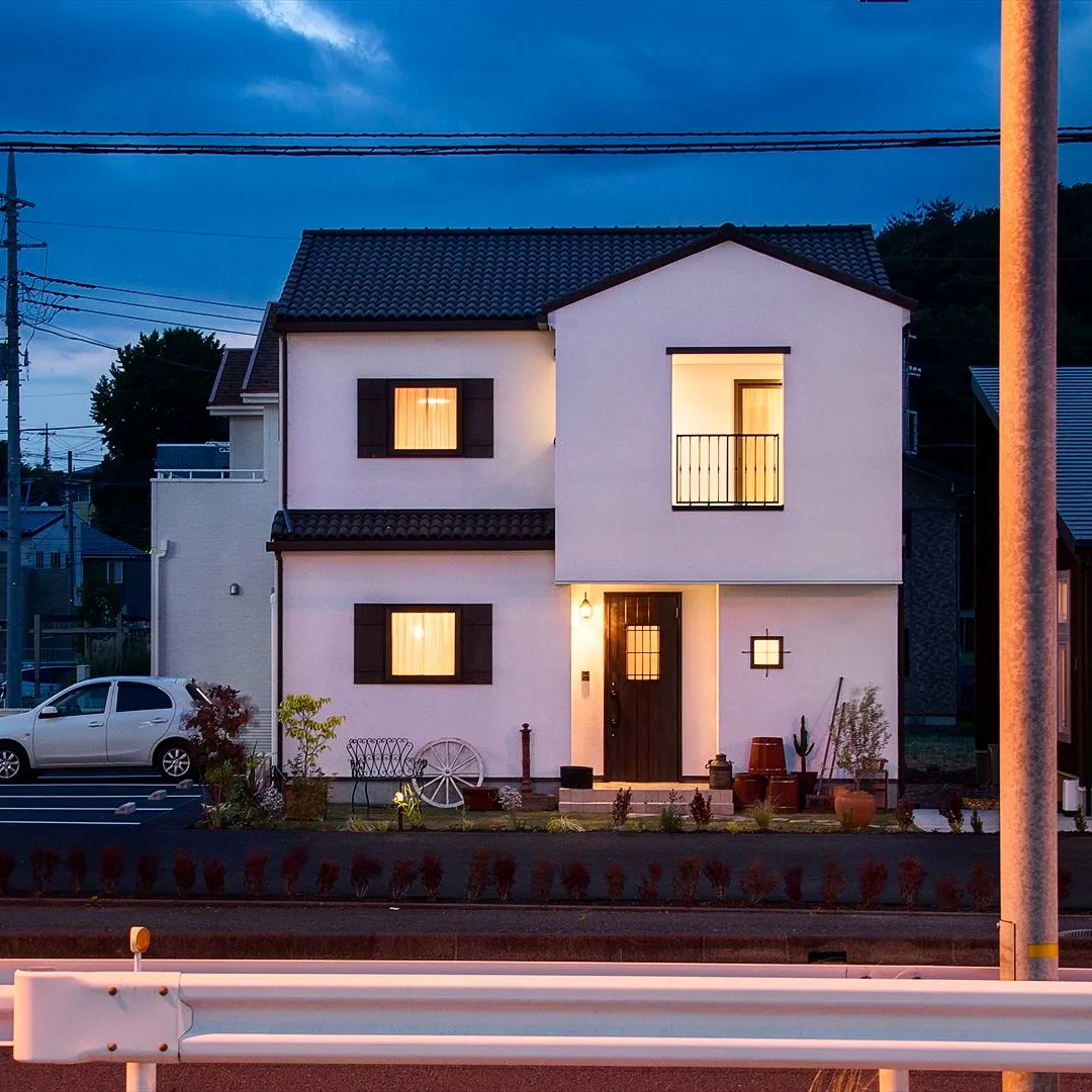 夕方に染まる空を背景に、ひっそりと佇む白い壁の家は、どこか懐...