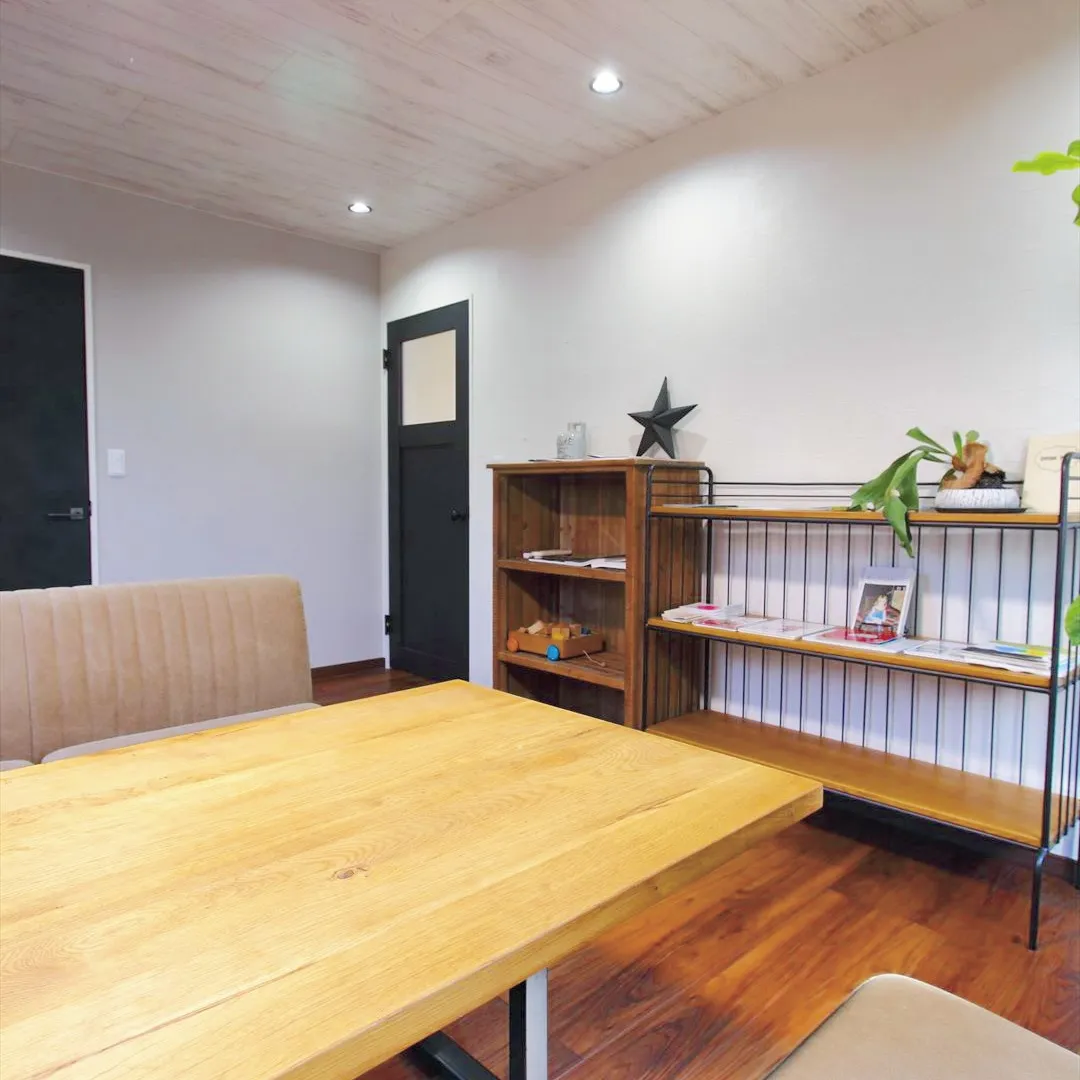 シンプルな白い壁に控えめな黒のドアがある応接室。